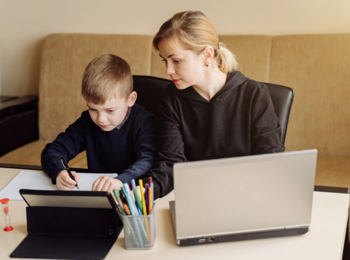 mother using laptop tablet teaching with her son online home his room 700x520 - Trik Menyiasati Pengeluaran yang Meningkat karena Sekolah Online