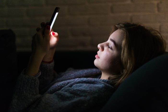 young beautiful woman using smart phone night bed technology social network insomnia concept min 700x467 - Stres Selama Work From Home? Coba Tips Berikut Ini