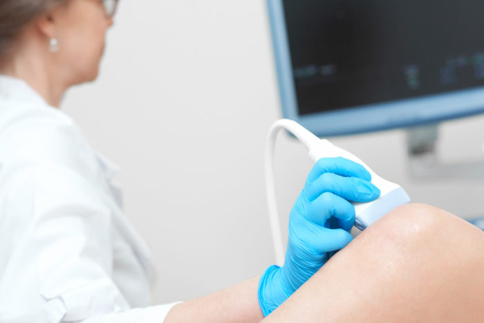 woman getting knee ultrasound scanning examination clinic 700x467 - Daftar Rumah Sakit dan Biaya Operasi Ganti Sendi Lutut di Malaysia